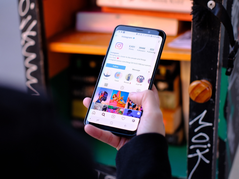 Foto mostra a mão de uma pessoa acessando o aplicativo do Instagram no celular