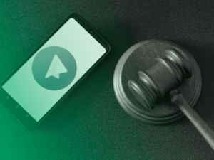 Celular com o aplicativo Telegram aberto ao lado de um malhete, representando o uso de mensagens como prova judicial.