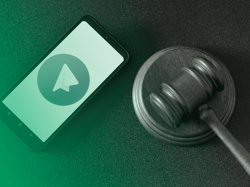 Celular com o aplicativo Telegram aberto ao lado de um malhete, representando o uso de mensagens como prova judicial.