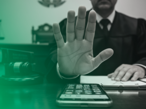 Juiz faz gesto de reprovação diante de um celular sobre a mesa, simbolizando a rejeição de provas digitais sem validade jurídica.